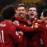 Zdjęcie przedstawia piłkarzy Liverpoolu w czerwonych trykotach celebrujących zdobytą bramkę