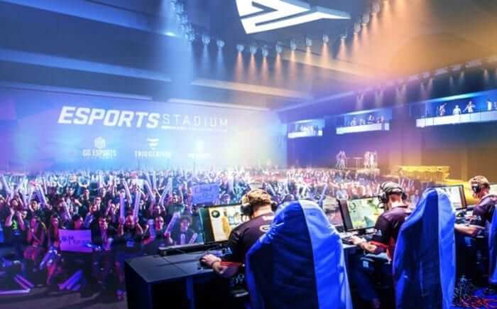 Obrazek przedstawia graczy i widzów podczas turnieju e-sportowego