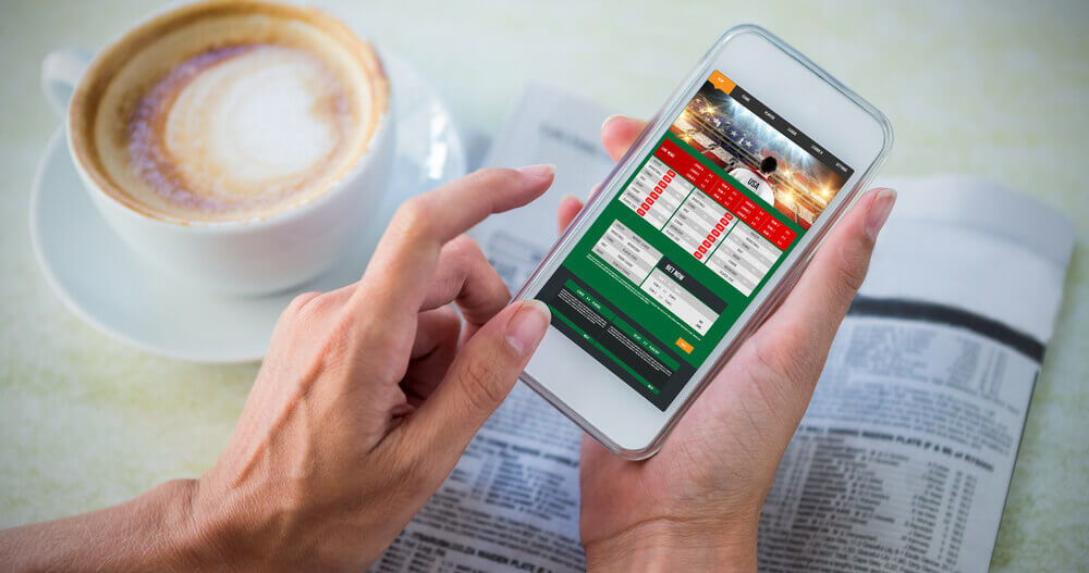 Obrazek przedstawia smartfon używany przez gracza chcącego obstawić mecze on-line