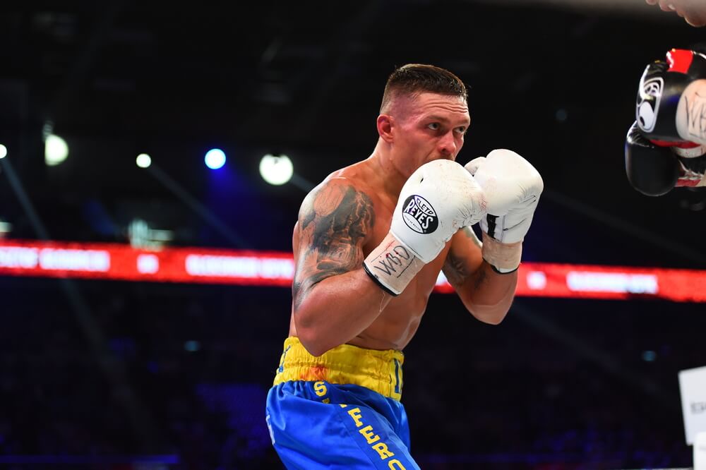 oleksandr usyk w białych rękawicach bokserskich trzymający gardę